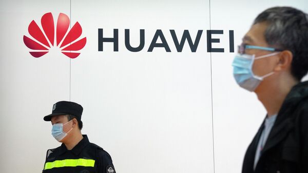 Em Pequim, um guarda de segurança se posiciona à esquerda próximo de um homem de máscara que passa em frente a um logo da Huawei durante feira de tecnologia na China, em 28 de setembro de 2021 - Sputnik Brasil