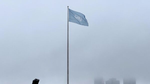 Escultura ao lado de bandeira hasteada das Nações Unidas junto da sede da ONU em Nova York, EUA, 17 de março de 2022 - Sputnik Brasil