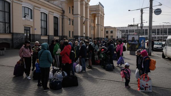 Deslocados internos se preparam para embarcar em um trem de evacuação que parte para Lvov, um dia depois de chegar como parte de um comboio humanitário da cidade sitiada de Mariupol, em uma estação ferroviária na cidade de Zaporozhie, em 22 de abril - Sputnik Brasil
