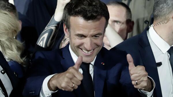 O presidente francês Emmanuel Macron mostra o polegar para cima após relatos de sua reeleição no domingo, 24 de abril de 2022, em Paris - Sputnik Brasil