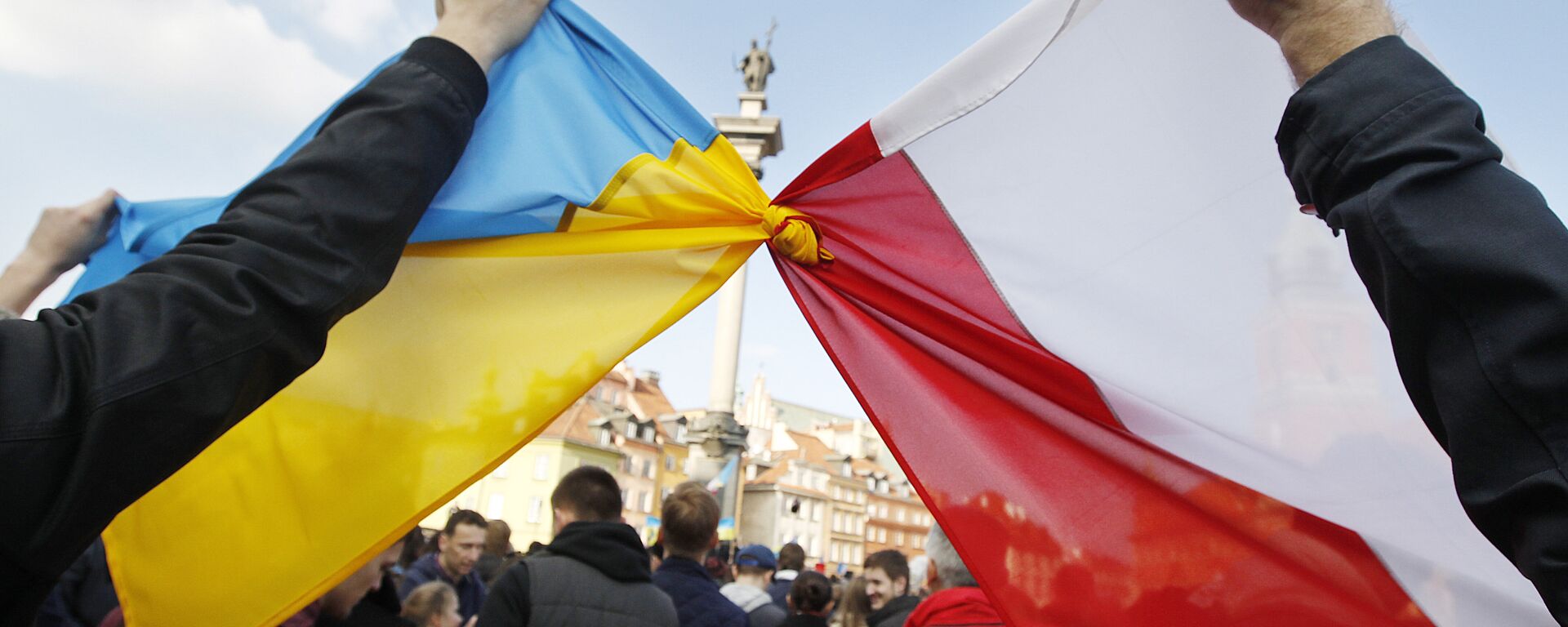 Pessoas seguram bandeiras polonesa (à direita) e ucraniana amarradas durante uma manifestação de apoio ao movimento de oposição na Ucrânia, em Varsóvia, Polônia, 23 de fevereiro de 2014 - Sputnik Brasil, 1920, 28.04.2022