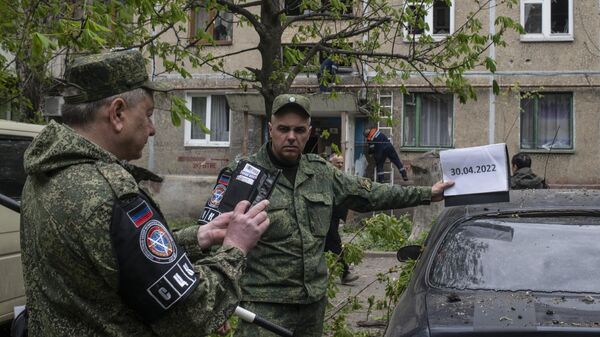Funcionários do Centro Conjunto de Controle e Coordenação do Cessar-Fogo e Estabilização da Linha Fronteiriça da República Popular de Donetsk inspecionam resultado de bombardeio pelas Forças Armadas da Ucrânia em Kirovsk, Donetsk em 30 de abril de 2022 - Sputnik Brasil