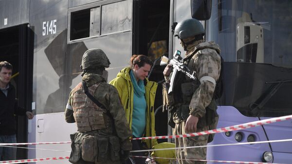 Residentes de Mariupol são escoltados por militares em um posto de evacuação, na República Popular de Donetsk, 1º de maio de 2022. - Sputnik Brasil
