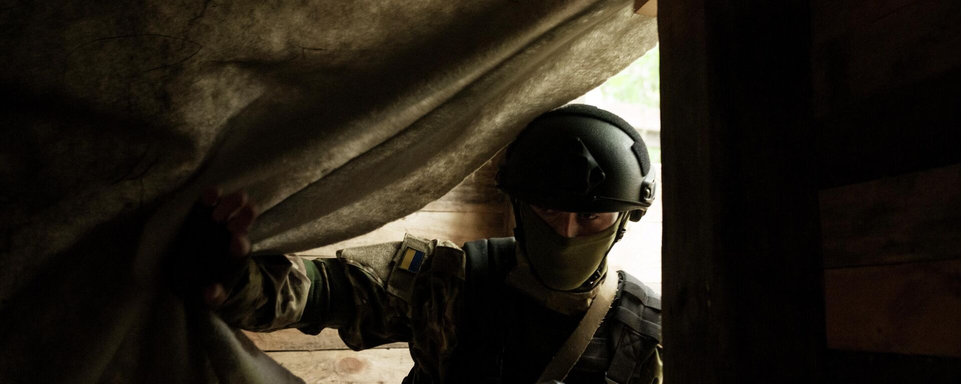 Um soldado da Guarda Nacional Ucraniana entra em um abrigo subterrâneo em uma posição perto de Kharkiv, Ucrânia, segunda-feira, 9 de maio de 2022 - Sputnik Brasil, 1920, 31.05.2026