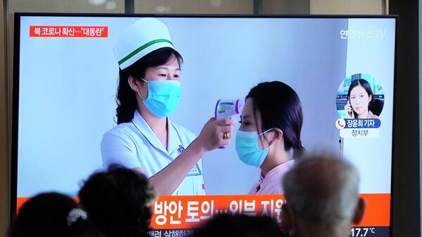 Pessoas assistem uma tela de televisão enquanto notícias sobre um surto de COVID-19 na Coreia do Norte são reportadas, em Seul, Coreia do Sul, 14 de maio de 2022 - Sputnik Brasil