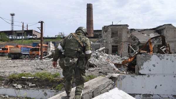 Soldado do batalhão Vostok da Milícia Popular de Donetsk contorna o território da fábrica de Azovstal, em Mariupol, 21 de maio de 2022 - Sputnik Brasil