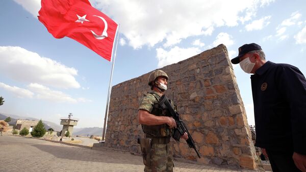Um soldado turco saúda o ministro da Defesa da Turquia, Hulusi Akar, na província turca de Hakkari, na fronteira com o Iraque, em 19 de junho de 2020 - Sputnik Brasil