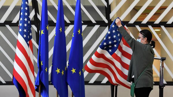 Membro da equipe de protocolo ajusta as bandeiras dos Estados Unidos e da União Europeia (UE) antes da chegada de chanceleres para encontro, em Bruxelas, na Bélgica, em 4 de março de 2022 (foto de arquivo) - Sputnik Brasil