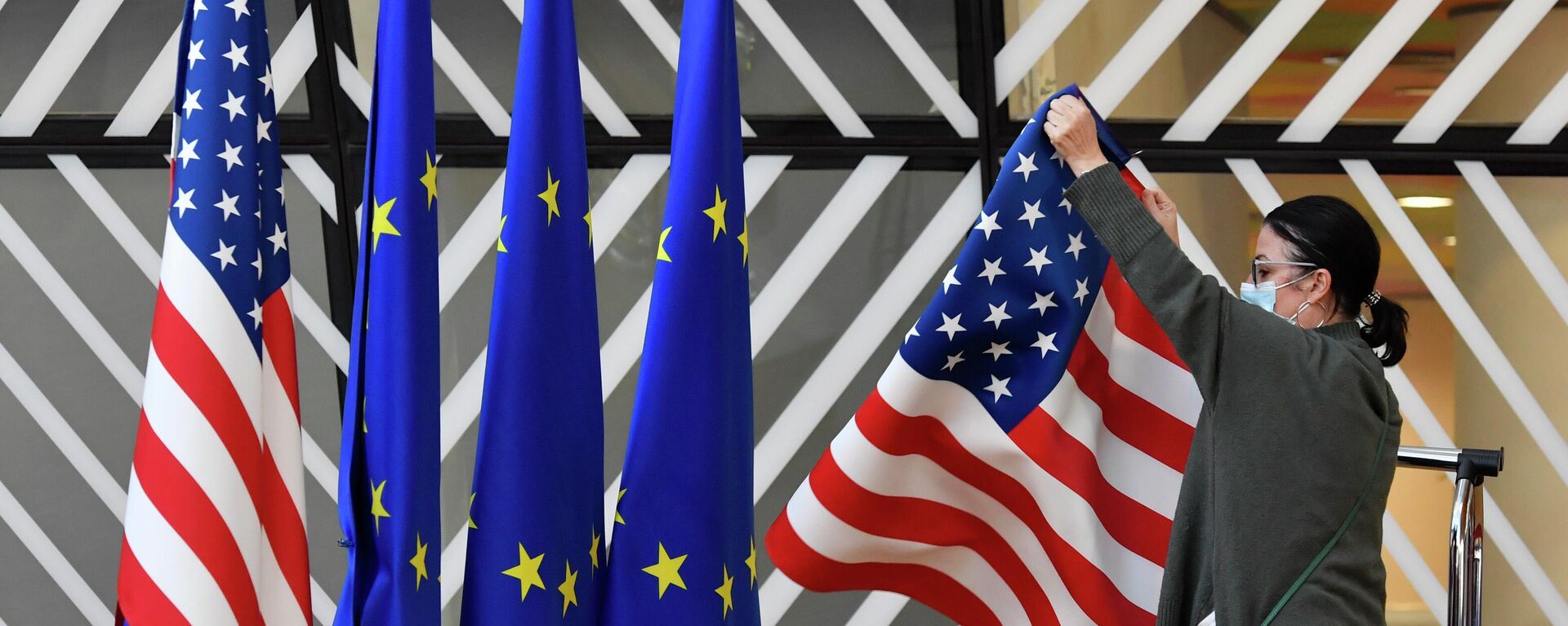 Membro da equipe de protocolo ajusta as bandeiras dos Estados Unidos e da União Europeia (UE) antes da chegada de chanceleres para encontro, em Bruxelas, na Bélgica, em 4 de março de 2022 (foto de arquivo) - Sputnik Brasil, 1920, 27.06.2022
