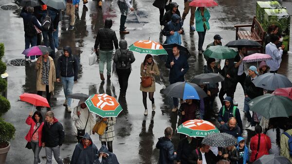 Espectadores caminham com guarda-chuvas após a chuva atrasar o início de partidas no torneio de tênis Roland Garros, em Paris, França, 5 de junho de 2019 - Sputnik Brasil