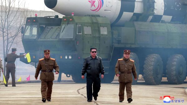 O líder norte-coreano Kim Jong-un andando perto do que a mídia estatal diz ser um novo tipo de balística intercontinental míssil (ICBM),  24 de março de 2022 - Sputnik Brasil