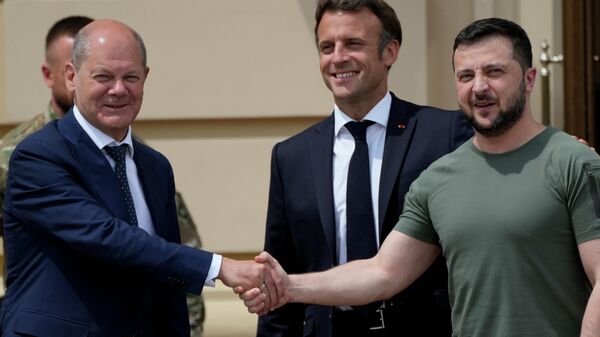 O chanceler alemão, Olaf Scholz (à esquerda), aperta a mão do presidente ucraniano, Vladimir Zelensky (à direita), enquanto o presidente francês, Emmanuel Macron, sorri, no Palácio Mariinsky em Kiev, Ucrânia, 16 de junho de 2022 - Sputnik Brasil