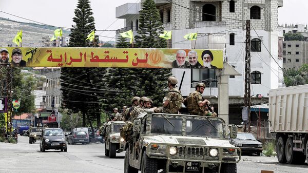 Veículos do Exército libanês passam por uma faixa do movimento muçulmano xiita libanês Hezbollah com texto em árabe dizendo a bandeira não cairá (foto de arquivo) - Sputnik Brasil