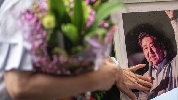 Pessoas fazem fila para colocar flores em um memorial improvisado do lado de fora da Estação Yamato-Saidaiji, onde o ex-primeiro-ministro japonês Shinzo Abe foi baleado em 8 de julho, em Nara, 9 de julho de 2022 - Sputnik Brasil