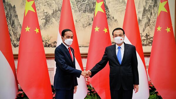 Nesta foto divulgada pelo Escritório de Imprensa e Mídia do Palácio Presidencial da Indonésia, o presidente indonésio Joko Widodo (E), aperta a mão do primeiro-ministro chinês Li Keqiang durante reunião em Pequim, China, 26 de julho de 2022 - Sputnik Brasil