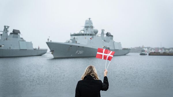 Trine Bramsen, ministra da Defesa dinamarquesa, acena com bandeiras do país para cumprimentar a chegada da fragata Iver Huitfeldt, que regressa a Korsoer, Dinamarca, 10 de dezembro de 2020. - Sputnik Brasil