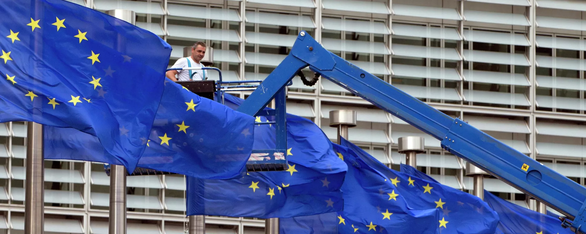Nesta foto, um trabalhador em um elevador ajusta as bandeiras da União Europeia (UE) em frente à sede, em Bruxelas, 23 de junho de 2016 - Sputnik Brasil, 1920, 24.06.2024