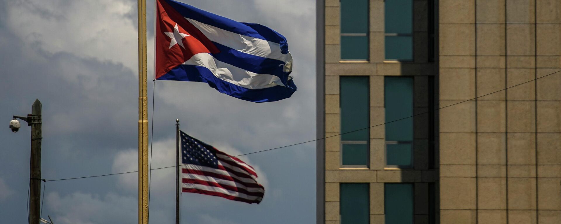 Bandeiras de Cuba e EUA fora da Embaixada dos EUA em Havana. Cuba, 17 de maio de 2022 - Sputnik Brasil, 1920, 16.01.2026