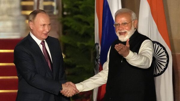 Vladimir Putin, presidente da Rússia (à esquerda), e Narendra Modi, primeiro-ministro da Índia, apertam as mãos durante encontro em Nova Deli, na Índia, em 6 de dezembro de 2021 - Sputnik Brasil