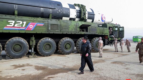 O líder norte-coreano Kim Jong-un andando perto do que a mídia estatal diz ser um novo tipo de míssil balístico intercontinental, 24 de março de 2022 - Sputnik Brasil