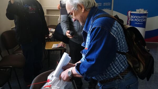 Homem vota em referendo sobre a integração da região de Kherson à Rússia em local de votação em Kherson, em 23 de setembro de 2022 - Sputnik Brasil