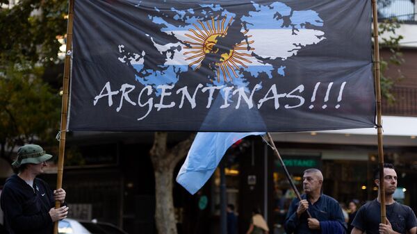 Homem segura bandeira retratando as ilhas Malvinas como território argentino junto da embaixada do Reino Unido em Buenos Aires, Argentina, 2 de abril de 2022 - Sputnik Brasil