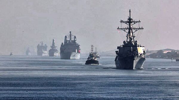 Esta imagem de folheto fornecida pela conta oficial no Twitter do comodoro da Marinha Real Steve Moorhouse, comandante do grupo de ataque de porta-aviões do Reino Unido, mostra uma visão dos navios do grupo de ataque navegando atrás do porta-aviões HMS Queen Elizabeth da Marinha Real através canal de Suez no Egito, 6 de julho de 2021 - Sputnik Brasil