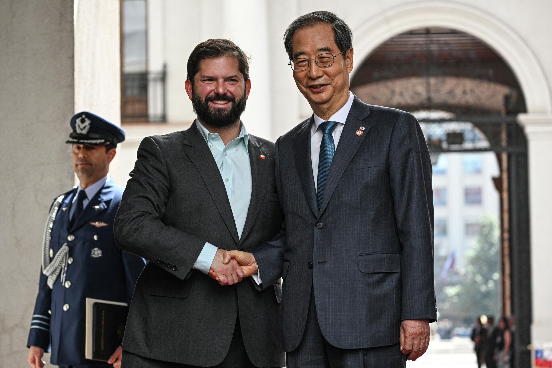 O presidente do Chile, Gabriel Boric (E) aperta a mão do primeiro-ministro da Coreia do Sul, Han Duck-Soo (D), após sua chegada ao palácio presidencial La Moneda em Santiago, em 11 de outubro de 2022. - Sputnik Brasil, 1920, 15.10.2022