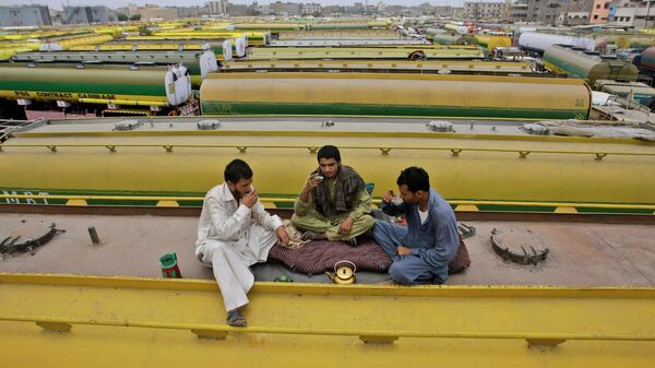 Motoristas paquistaneses bebem chá em cima de um petroleiro, que foi usado para transportar suprimentos de combustível da OTAN para o Afeganistão, enquanto estacionado com outros petroleiros em um complexo em Karachi, Paquistão, 4 de junho de 2012 - Sputnik Brasil