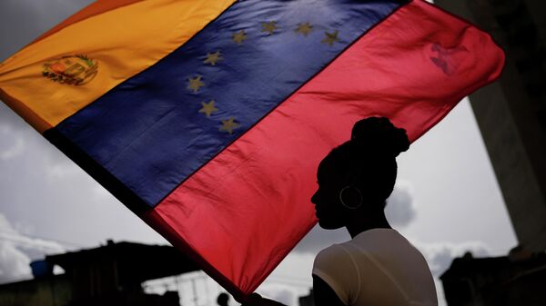 Mulher segura bandeira venezuelana durante a festa de São João Batista, no bairro de San Agustín. Caracas, 24 de junho de 2022 - Sputnik Brasil
