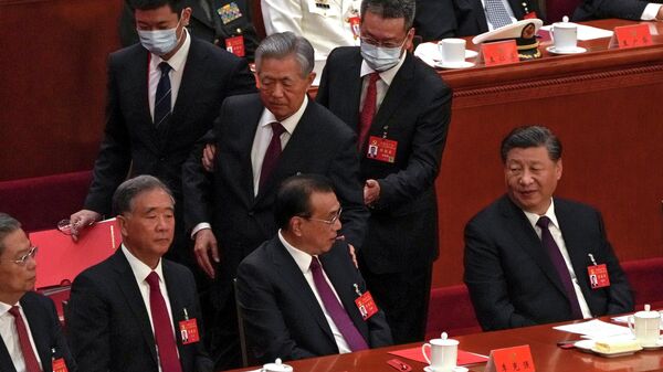 O presidente chinês Xi Jinping, à direita, observa o ex-presidente chinês Hu Jintao, ao centro, tocando o ombro do primeiro-ministro Li Keqiang, ao centro, enquanto ele é ajudado a deixar o salão durante a cerimônia de encerramento do 20º Congresso Nacional da decisão da China Partido Comunista no Grande Salão do Povo em Pequim, 22 de outubro de 2022 - Sputnik Brasil