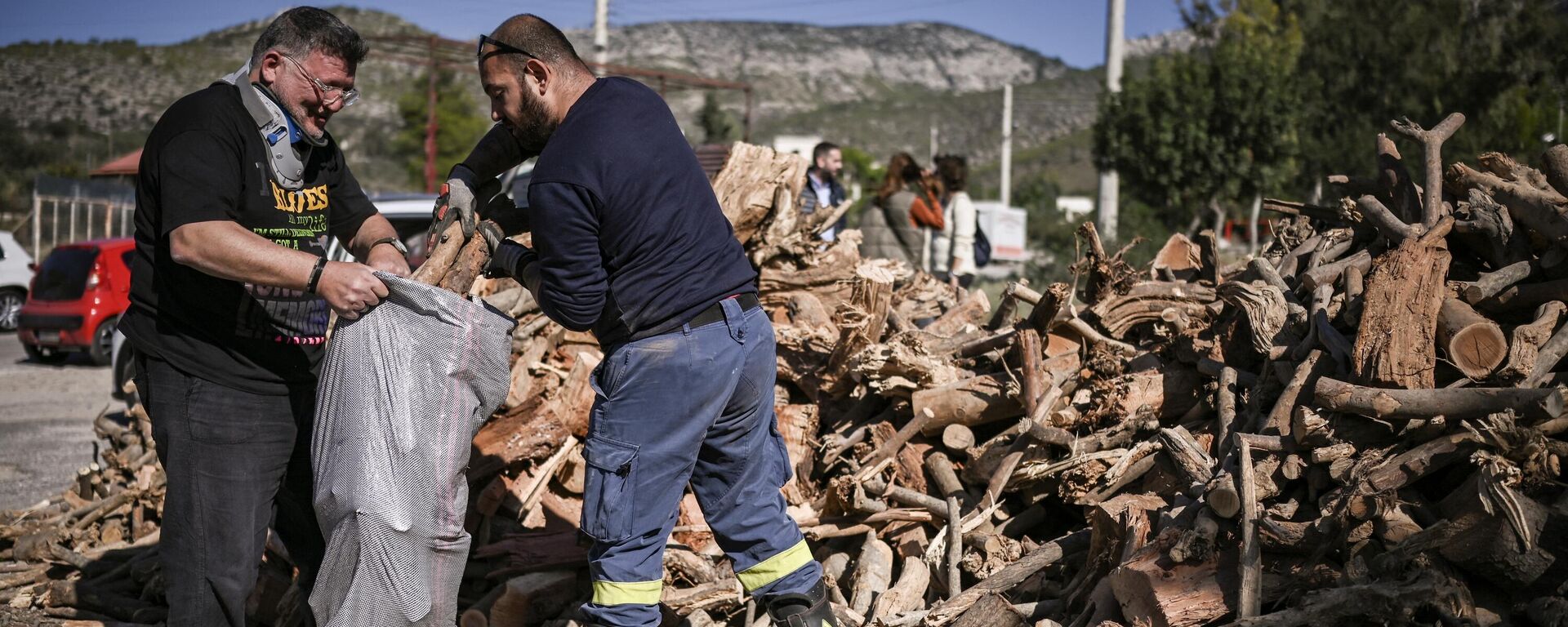 Moradores do subúrbio de Glyfada, no sul de Atenas, coletam lenha oferecida pelo município em 20 de outubro de 2022 - Sputnik Brasil, 1920, 25.10.2022