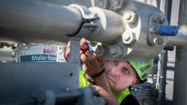 Funcionário do gasoduto Nord Stream 2 trabalha em plataforma na estação de recebimento do mar Báltico, onde 6,5 milhões de metros cúbicos de gás natural por hora serão processados ​​e entregues aos gasodutos a jusante na pressão certa, em Lubmin, na Alemanha - Sputnik Brasil