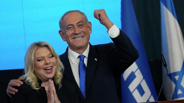 O ex-primeiro-ministro israelense e chefe do partido Likud, Benjamin Netanyahu e sua esposa Sara gesticulam após os primeiros resultados das pesquisas de boca de urna para a eleição parlamentar israelense na sede de seu partido em Jerusalém, 2 de novembro de 2022 - Sputnik Brasil