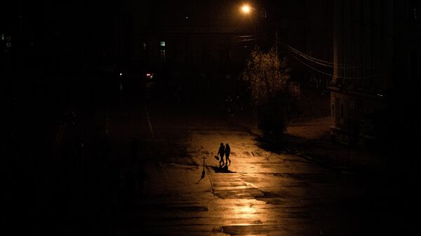 Pessoas caminham em escuro parcial durante blecaute em Kiev, capital da Ucrânia, em 6 de novembro de 2022 - Sputnik Brasil