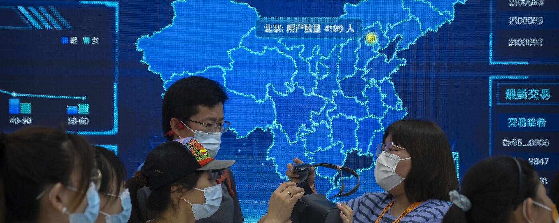 Visitantes usando máscaras se preparam para colocar um fone de ouvido de realidade virtual em frente a um mapa digital da China em um estande na Feira Internacional de Comércio de Serviços da China (CIFTIS) em Pequim, 3 de setembro de 2022 - Sputnik Brasil, 1920, 20.11.2022