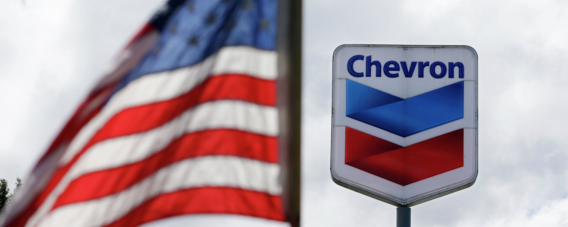 A bandeira dos Estados Unidos tremula em frente a um posto de gasolina da Chevron em Blaine, Washington, EUA, 23 de maio de 2013 - Sputnik Brasil, 1920, 02.12.2022