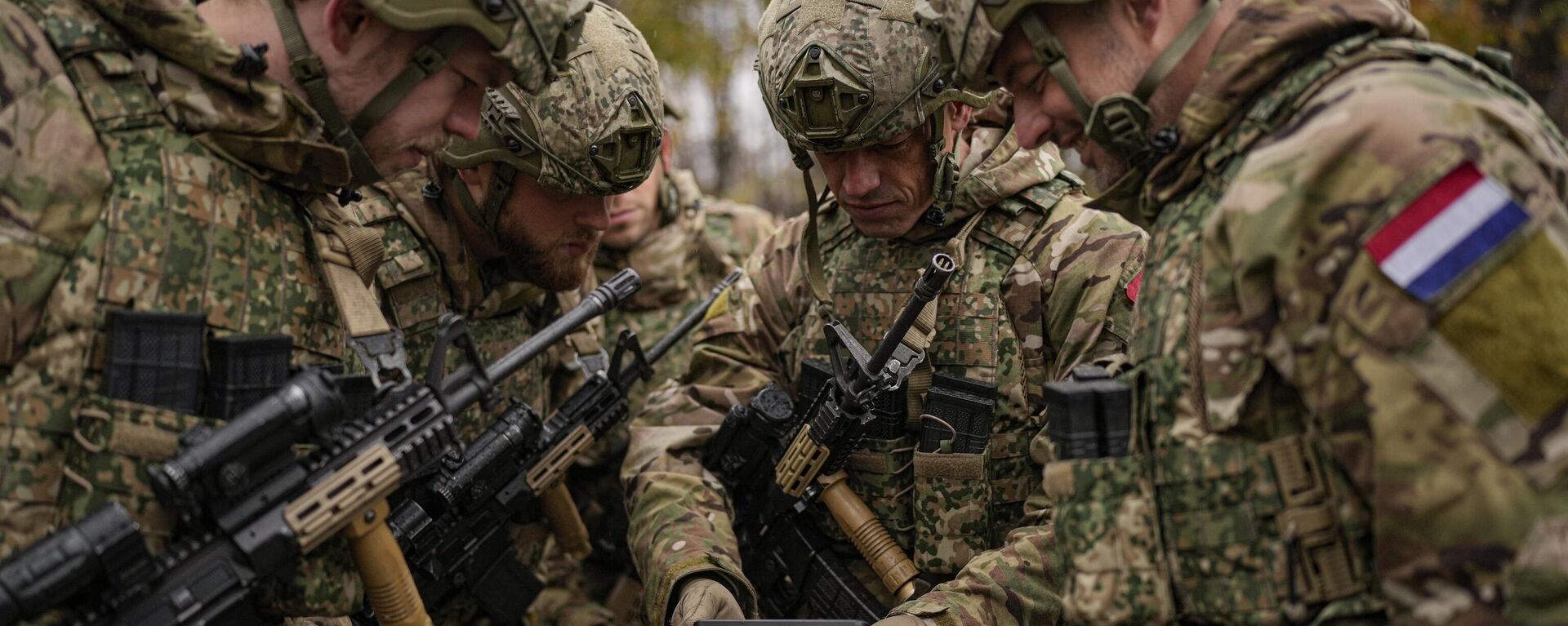 Militares dos Países Baixos assistem a uma transmissão ao vivo em um telefone celular antes do desfile do dia nacional em Bucareste, Romênia, quinta-feira, 1º de dezembro de 2022 - Sputnik Brasil, 1920, 20.01.2023