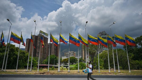 Pessoa passa ao lado de uma série de bandeiras venezuelanas em uma rodovia em Caracas, Venezuela, 22 de abril de 2022 - Sputnik Brasil