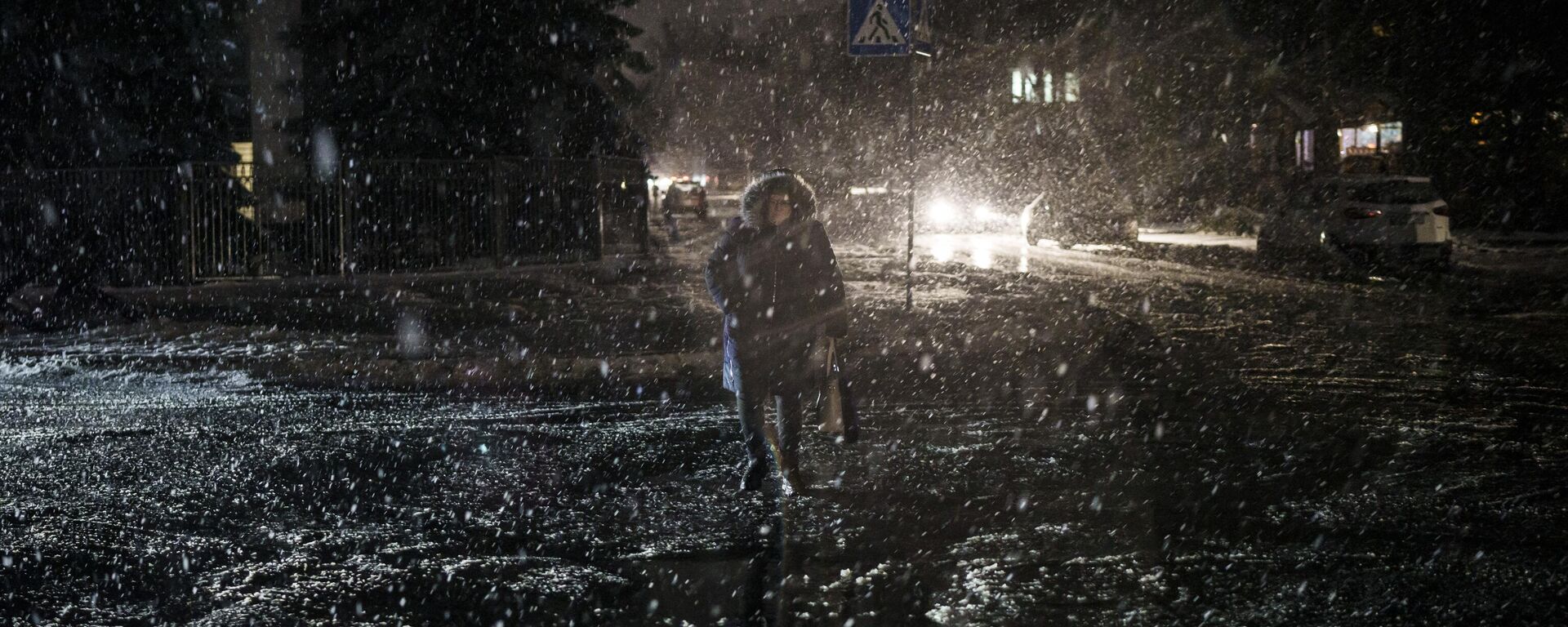 Uma mulher atravessa a rua durante uma nevasca, enquanto a falta de energia continua em Kiev, Ucrânia, 16 de dezembro de 2022 - Sputnik Brasil, 1920, 20.12.2022