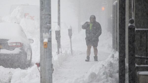 Uma pessoa caminha pelo centro da cidade em Buffalo, Nova Iorque, sob forte volume de neve, 18 de novembro de 2022 - Sputnik Brasil