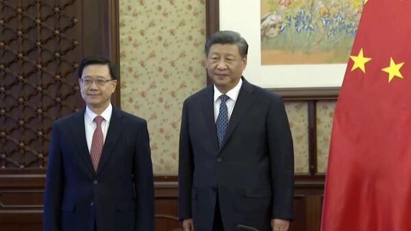 O chefe executivo de Hong Kong, John Lee (à esquerda), ao lado do presidente chinês, Xi Jinping (à direita), durante encontro em Pequim, China, 23 de dezembro de 2022 - Sputnik Brasil