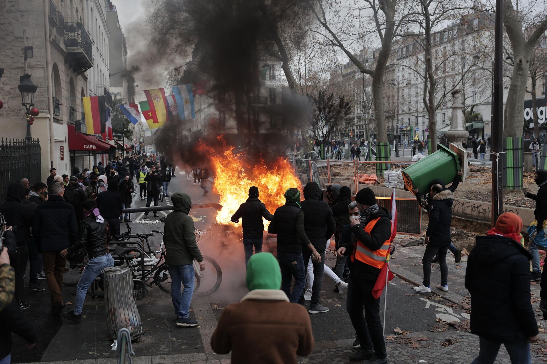 Pessoas protestam ao lado de uma barricada em chamas durante manifestação contra o recente tiroteio perto do centro cultural curdo em Paris, 24 de dezembro de 2022 - Sputnik Brasil, 1920, 26.12.2022