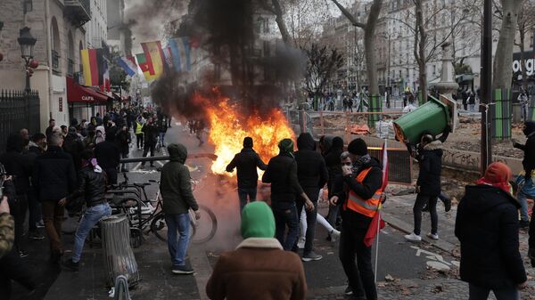 Pessoas protestam ao lado de uma barricada em chamas durante manifestação contra o recente tiroteio perto do centro cultural curdo em Paris, 24 de dezembro de 2022 - Sputnik Brasil