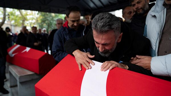 Homem lamenta morte de sua filha, abraçando o caixão em que ela foi colocada para cerimônia fúnebre, após explosão em Istambul, Turquia, 14 de novembro de 2022 - Sputnik Brasil