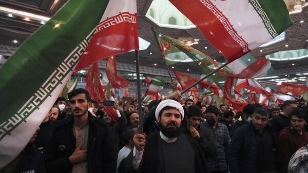Enlutados agitam bandeiras iranianas e islâmicas durante uma cerimônia que marca o aniversário da morte do general da Guarda Revolucionária Qassem Soleimani na Grande Mesquita Imam Khomeini em Teerã, Irã, 3 de janeiro 2023 - Sputnik Brasil
