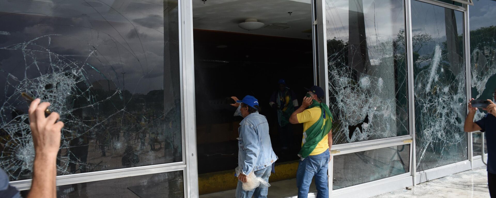 Manifestantes bolsonaristas diante de vidraças destruídas no Supremo Tribunal Federal (STF), em meio à invasão da Praça dos Três Poderes e de prédios públicos em Brasília (DF), em 8 de janeiro de 2023 - Sputnik Brasil, 1920, 07.06.2024