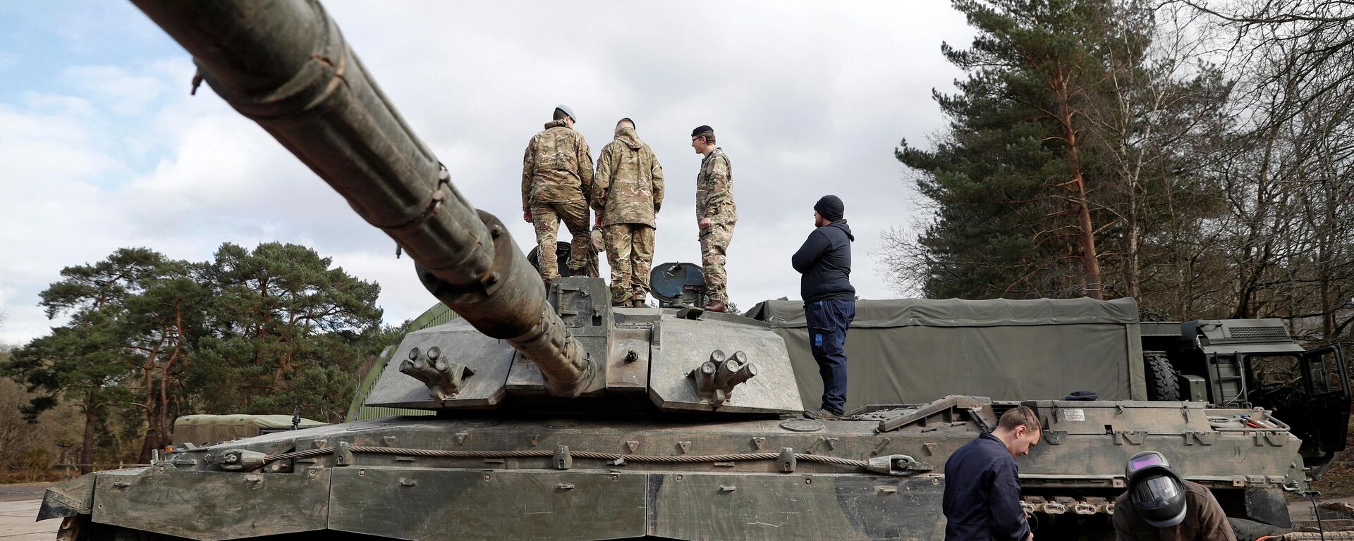 Soldados trabalham em um tanque de batalha principal Challenger 2 durante o exercício de treinamento dos Royal Electrical & Mechanical Engineers chamado Iron Challenge na área de treinamento de Longmoor, perto de Bordon, Hampshire, em 14 de março de 2022 - Sputnik Brasil, 1920, 11.01.2023