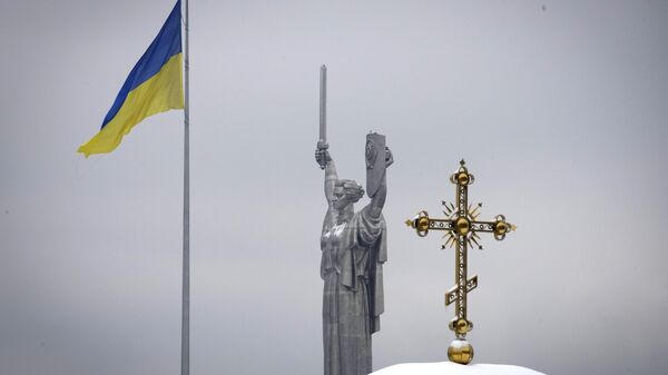 Bandeira ucraniana ao lado da cruz do monastério Pecherskaya Lavra e o Monumento da Terra-Mãe em Kiev, Ucrânia, 22 de novembro de 2022 - Sputnik Brasil