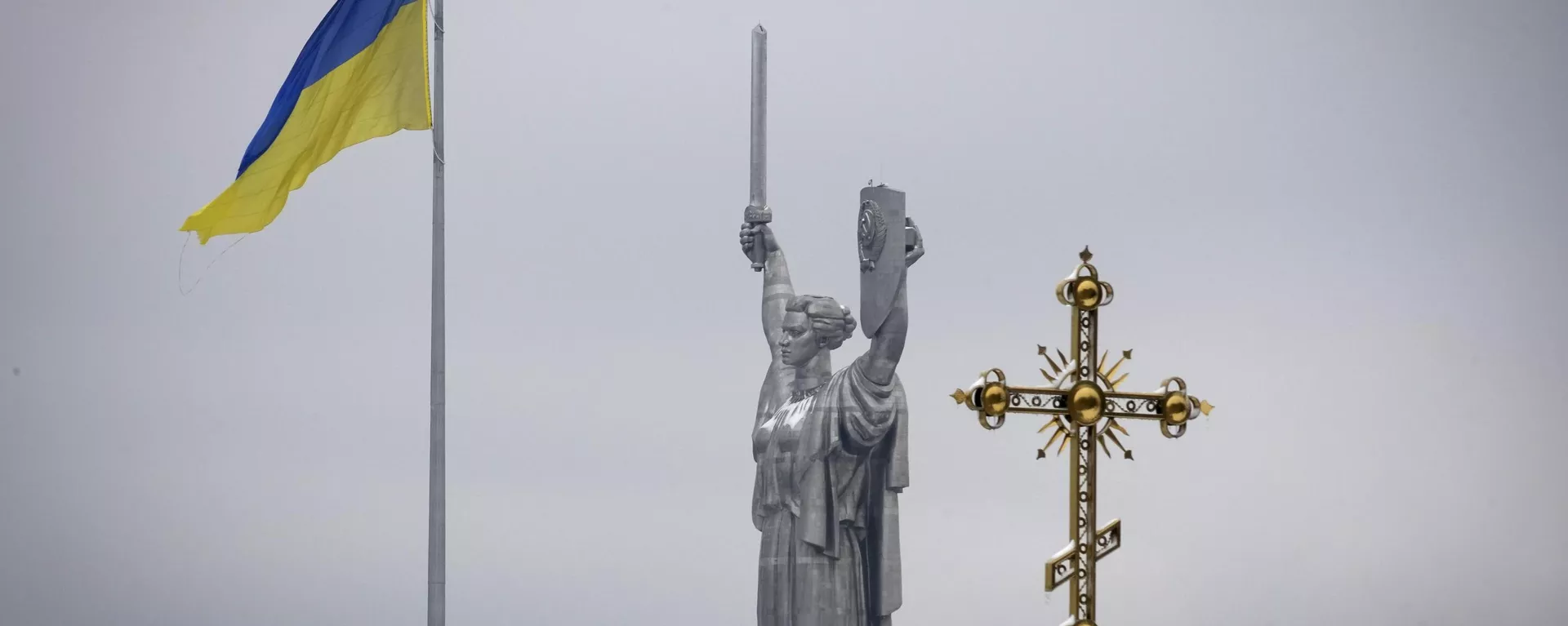 Bandeira ucraniana ao lado da cruz do monastério Pecherskaya Lavra e o Monumento da Terra-Mãe em Kiev, Ucrânia, 22 de novembro de 2022 - Sputnik Brasil, 1920, 03.02.2025